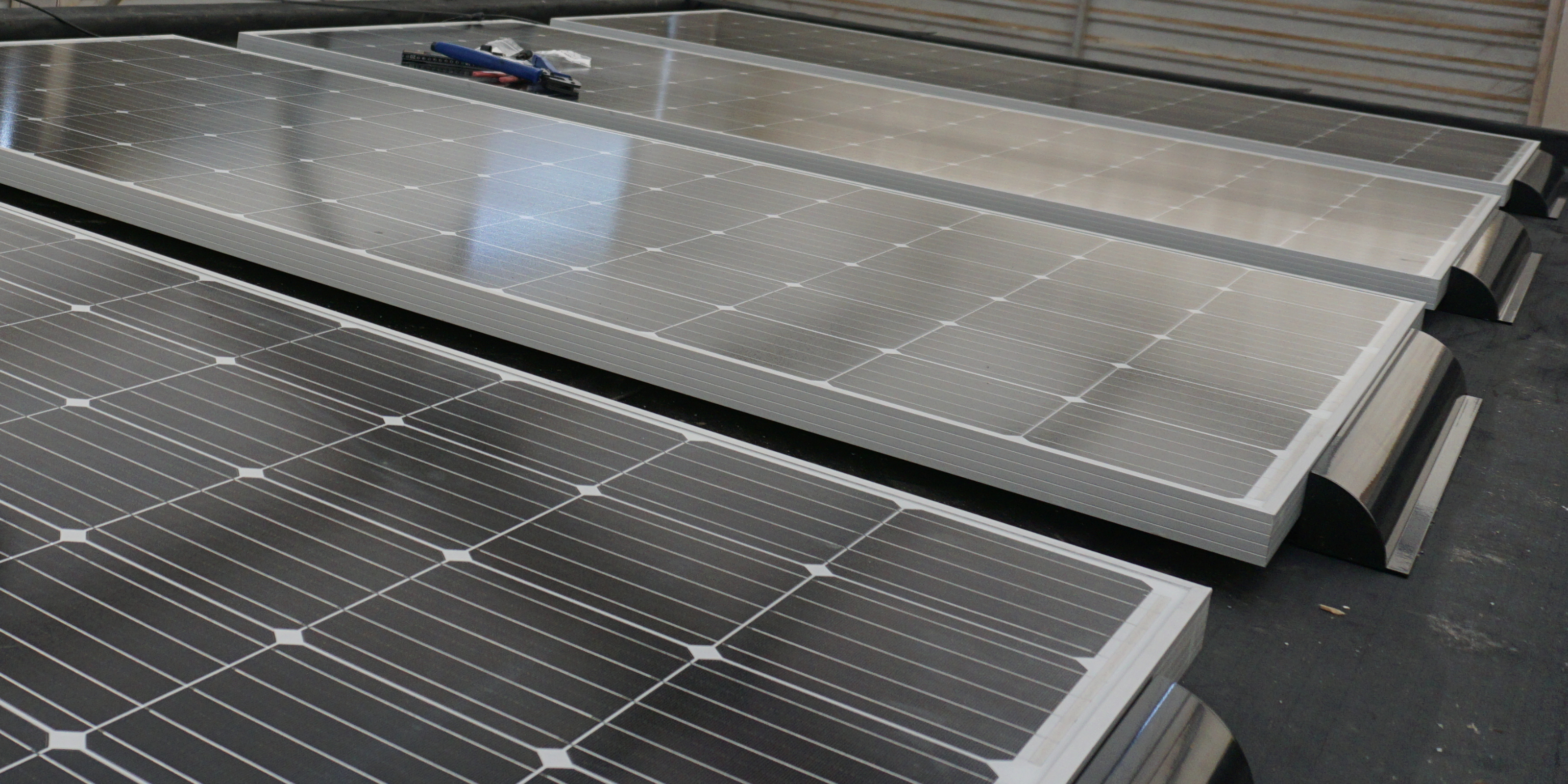 Mehrere Solarmodule werden mit Halterungen vormontiert.