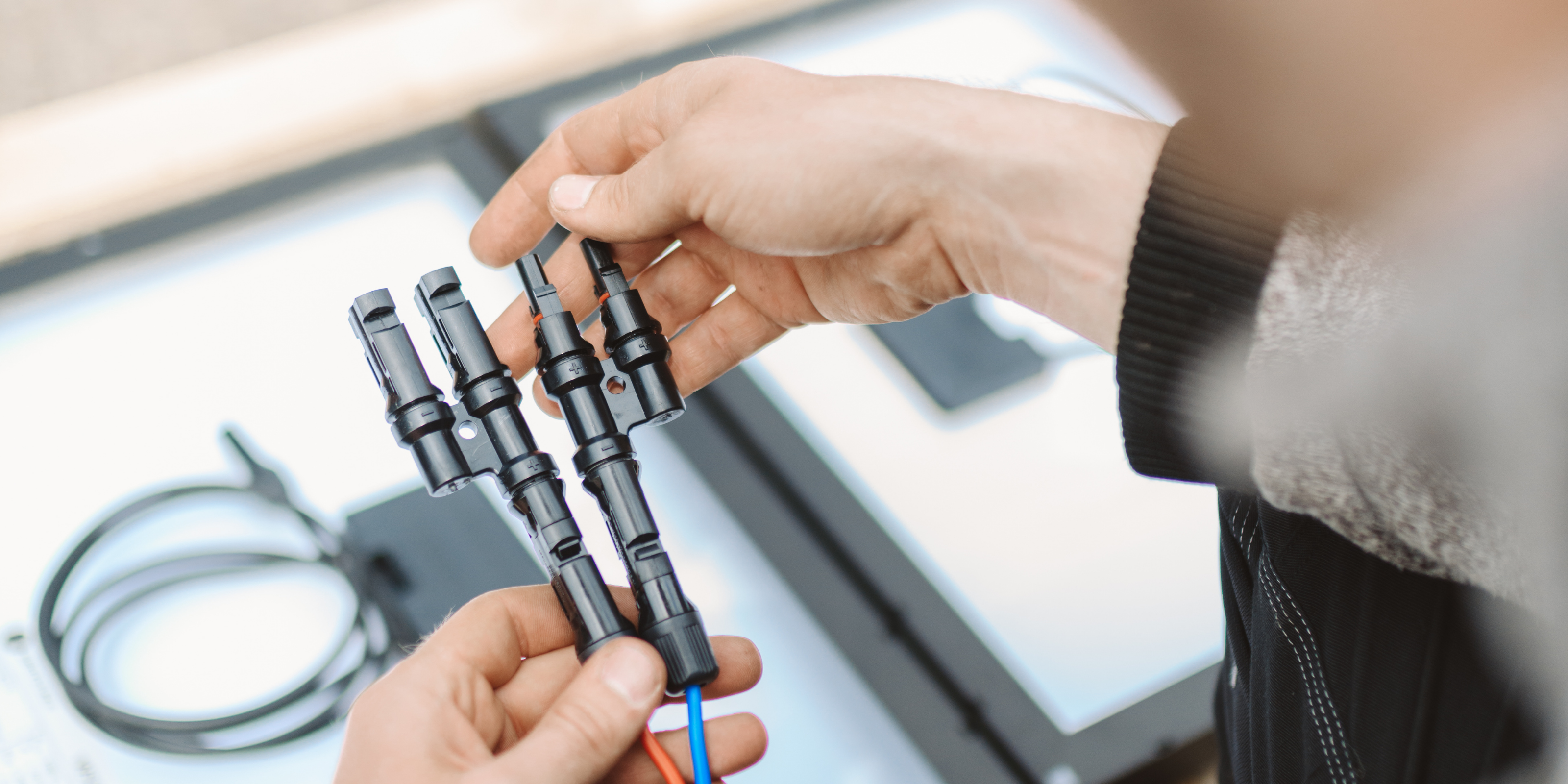 Ein Solarstecker, festgehalten von einer Person in der Nahansicht.
