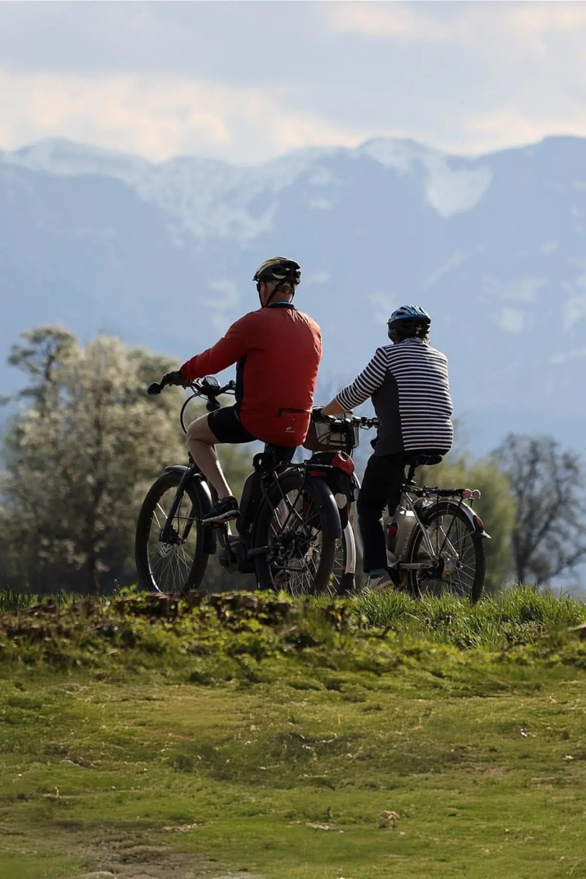 Ein Paar fährt durch eine grüne Landschaft mit E-Bikes.