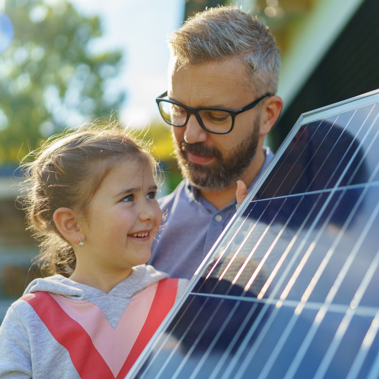Vater und Tochter betrachten die eingebauten Solarmodule im Rahmen des neuen Balkonkraftwerkes.