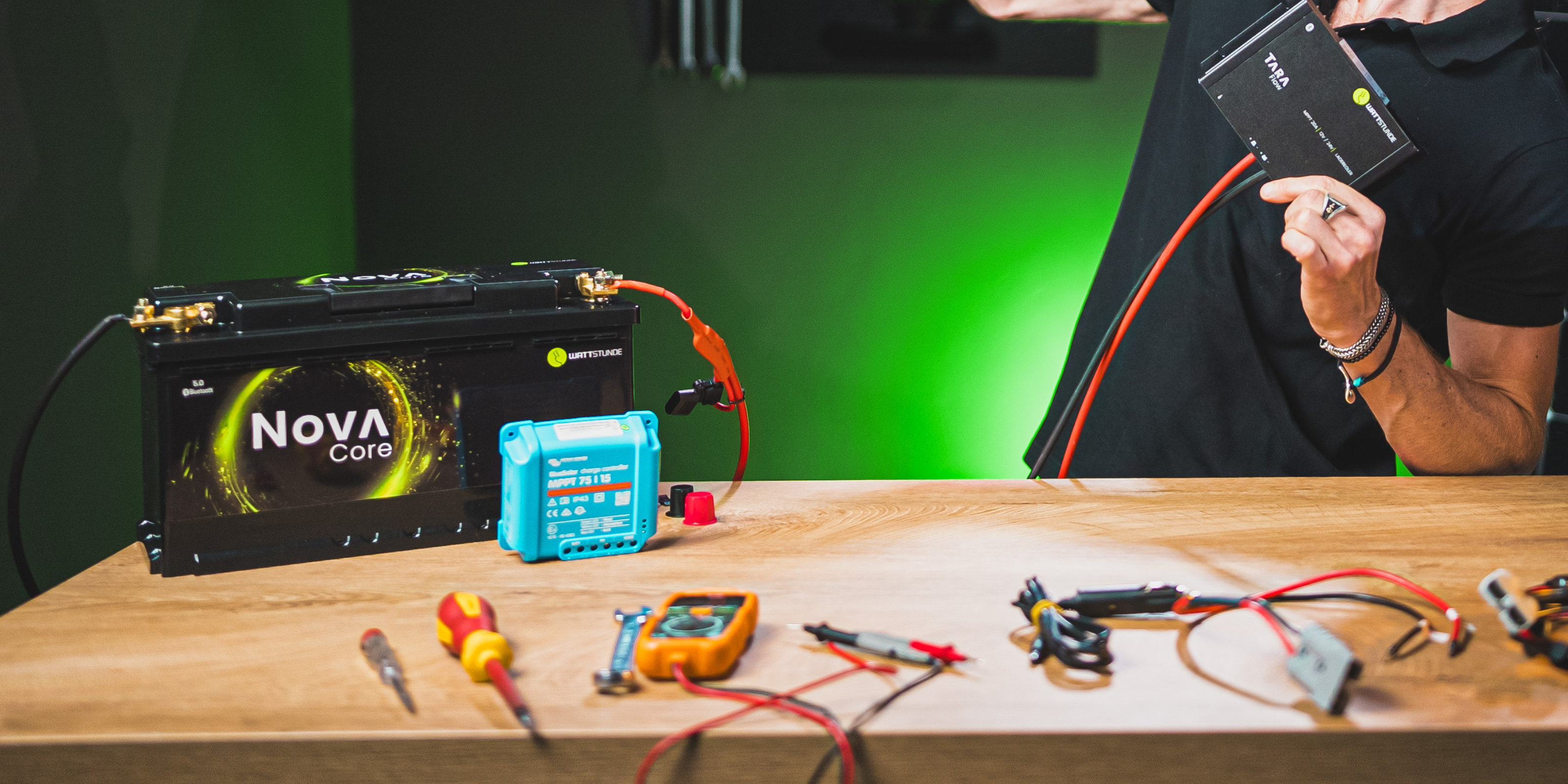 Ein Montagetisch mit Werkzeuge, eine Batterie, ein Wechselrichter und ein DC-DC Wandler. Allesamt werden miteinander verbunden.