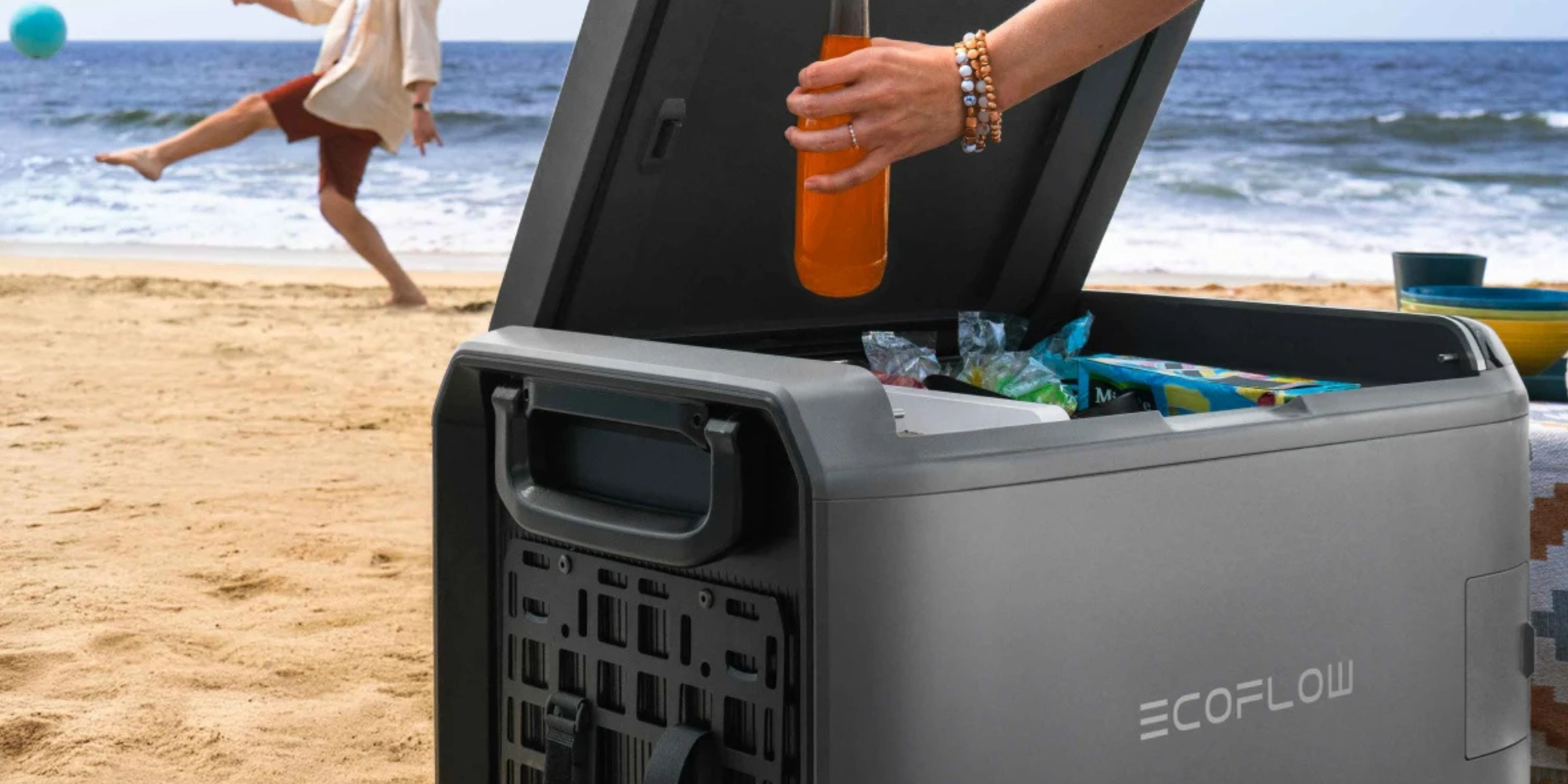 Eine offene EcoFlow-Glacier-Kühlbox, die geöffnet am Strand steht. Darin befinden sich diversen Getränke.