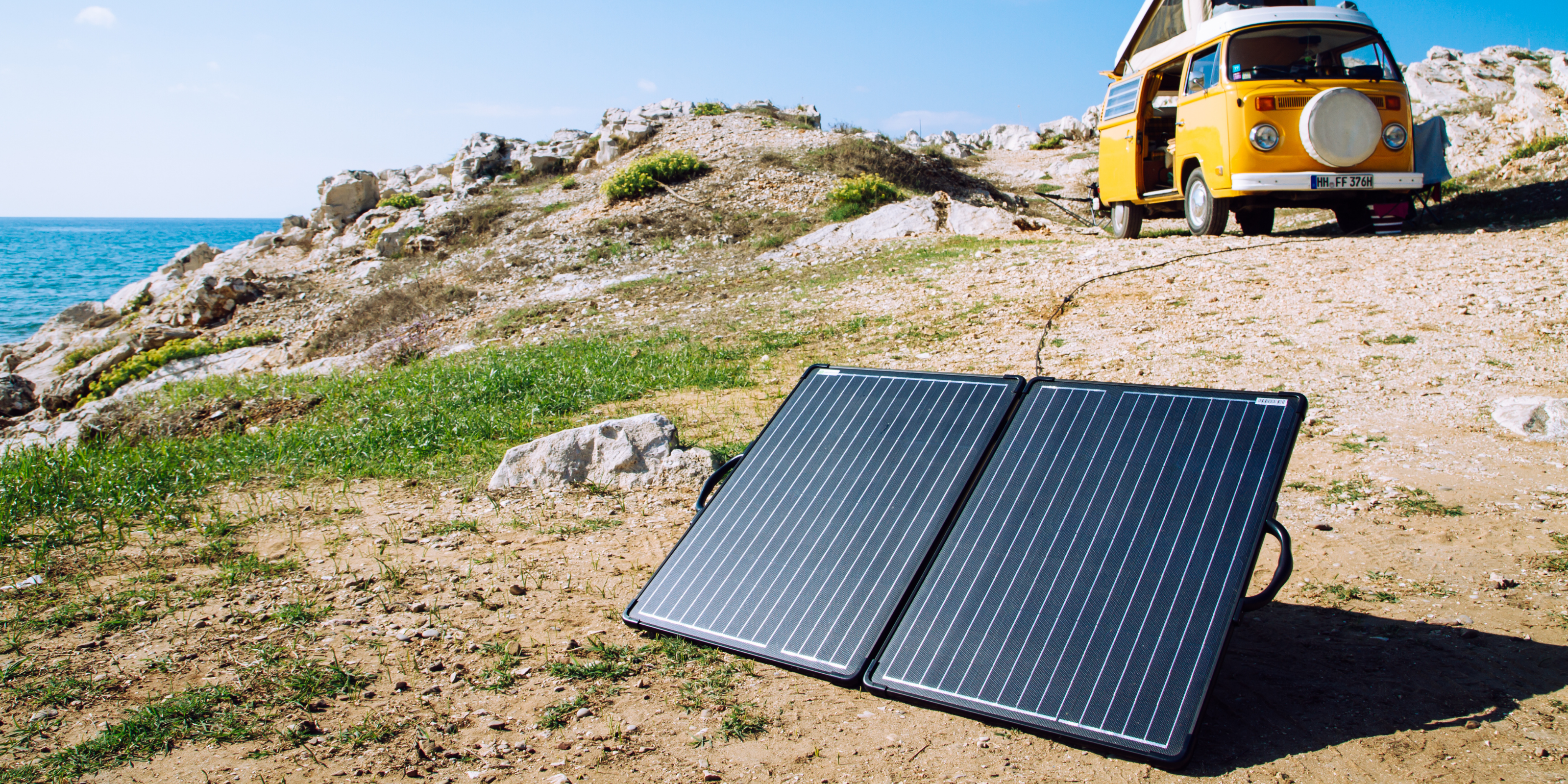 Ein Solarkoffer steht vor einem Reisefahrzeug.