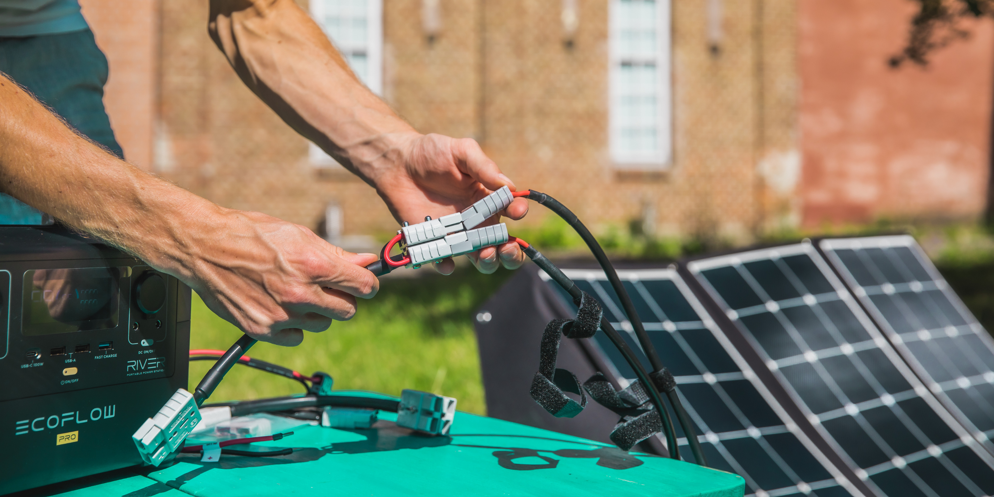Ein Mann schließt eine Powerstation an eine Solartasche an.