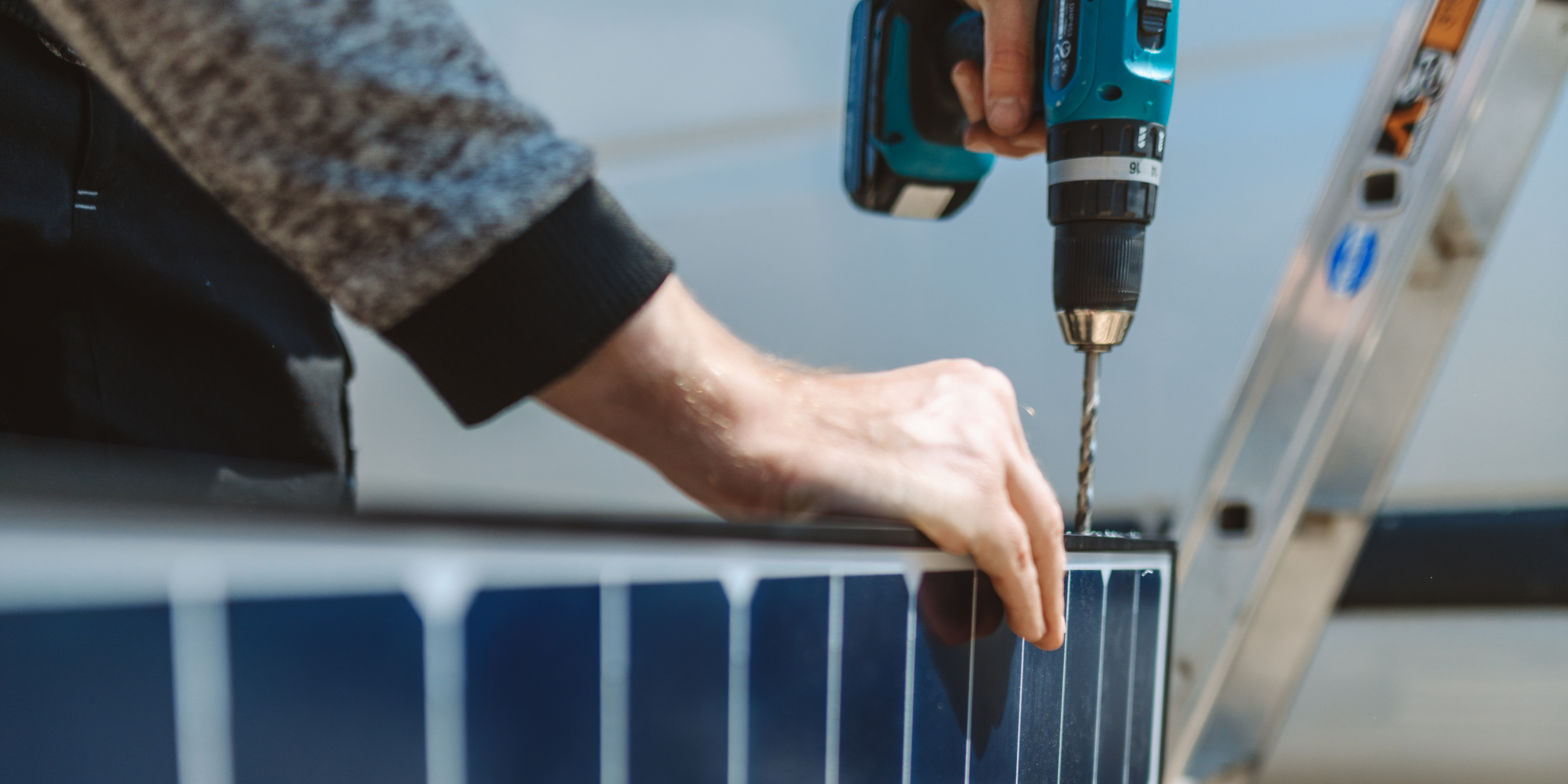 Eine Person bohrt ein Loch in die Seite eines Solarmodules von WATTSTUNDE, um dort eine Halterung zu montieren.