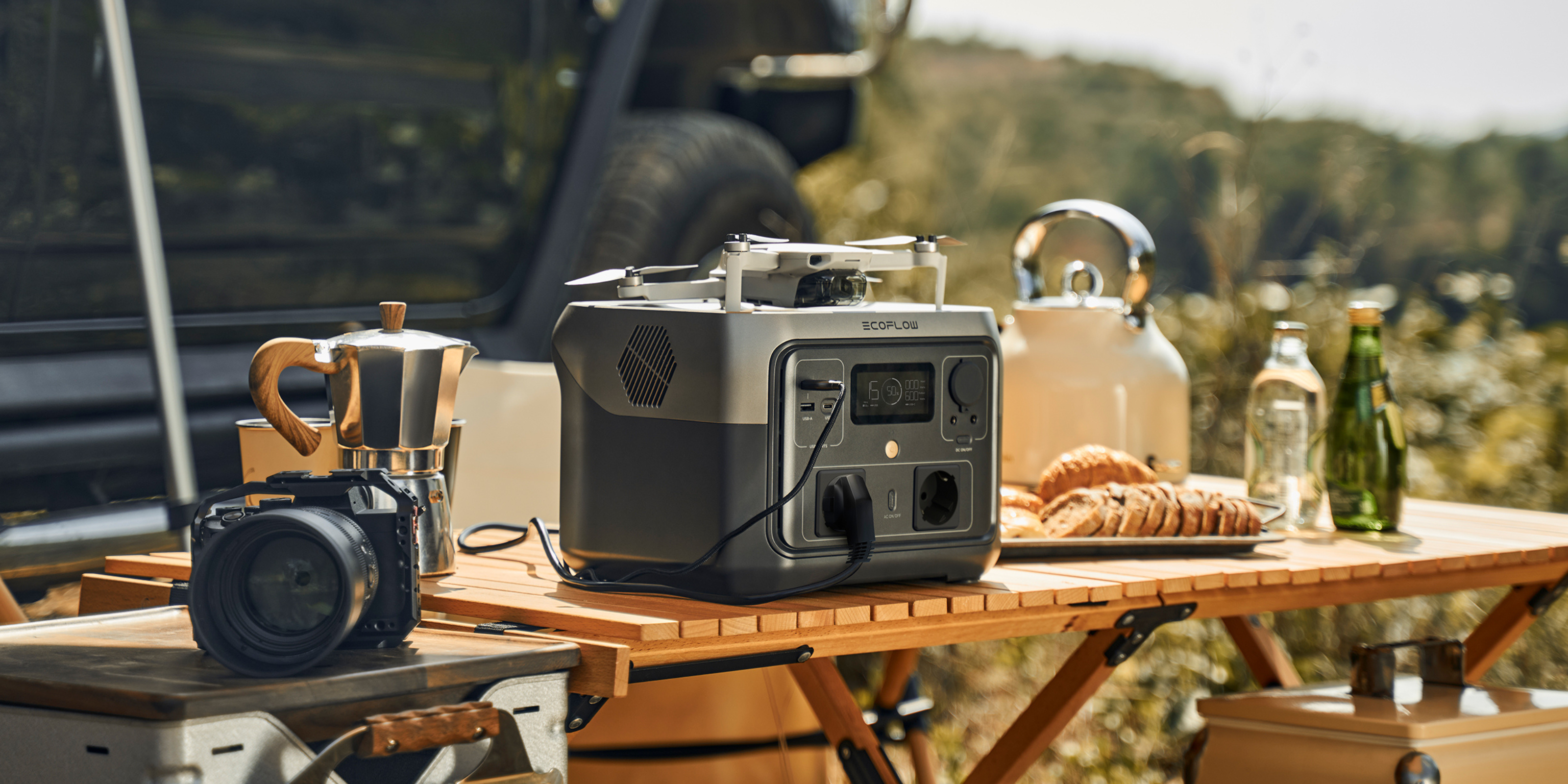 Powerstation auf einem Campingtisch - daneben ist eine Kamera, die von der Powerstation aufgeladen wird.